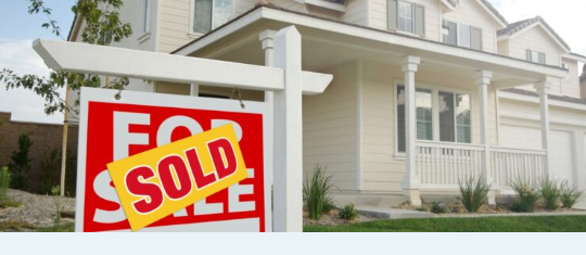 A family outside their sold home